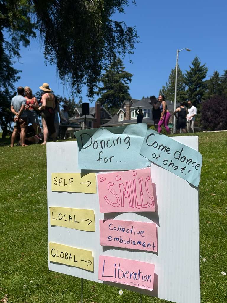 'Dancing for self, local, global' handmade sign