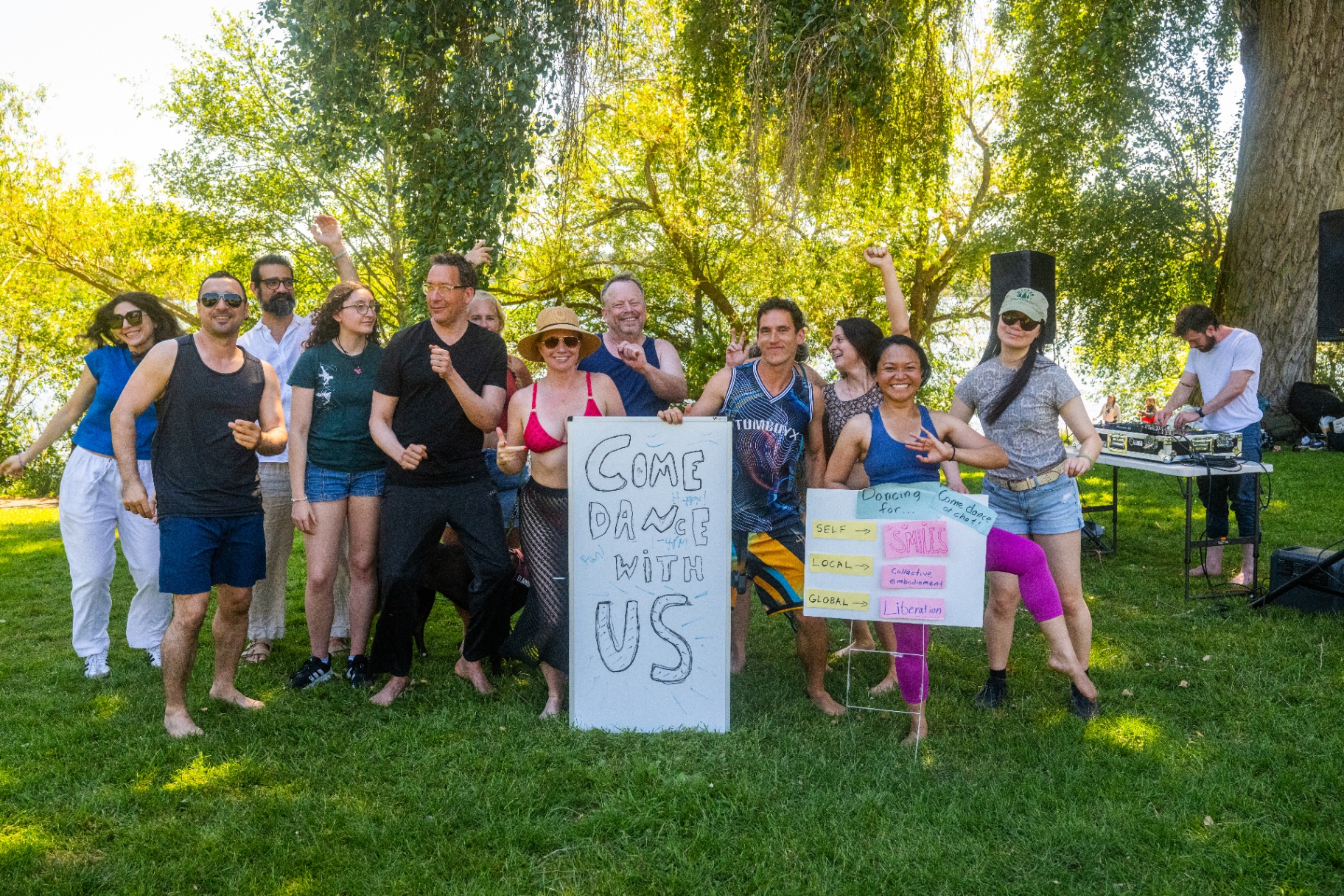 Light Beam Dance community holding a 'Come Dance With Us' sign